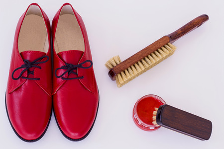 Isolated red shoes and means on care of footwear - shoe-polish and brushの写真素材