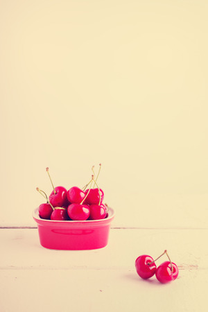 Ripe cherries on a red plate, selective focus.の写真素材