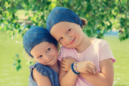 Cute funny little girls (sisters) smile, selective focus.の写真素材