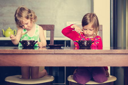 Two little girls don't want to eat. The image is tinted.の写真素材