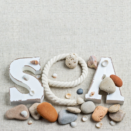 Concept of the summer time with sea shells and stones. Decorative letters SEA. Summer time, sea vacation.の写真素材