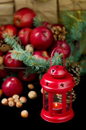 Christmas and New year. Apples with pine cones and nuts in a basket with fir branches. Gifts and candles.の写真素材