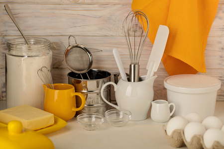 Kitchen utensils, tools and products for homemade cakes on a light wooden background. Selective focus.の写真素材