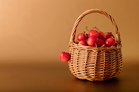 Cherries in a basket on a gold background. Selective focus.の写真素材