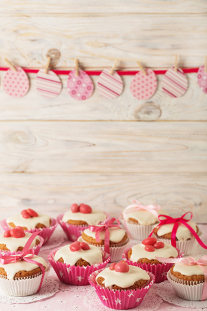 Easter cupcakes with white icing decorated with pink candy and ribbons. Selective focus.の写真素材