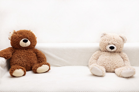 Children's toys - bears of brown and beige color are sitting on the sofa. Selective focus.の写真素材