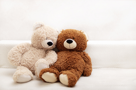 Children's toys - bears of brown and beige color are sitting on the sofa. Selective focus.の写真素材