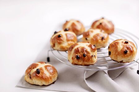 Buns marked with a cross and containing dried fruit, traditionally eaten during Lent. Selective focus.の写真素材