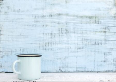 Enameled mugs in retro style on an old wooden background. Selective focus.の写真素材