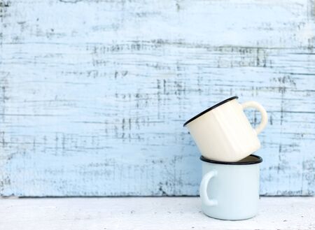 Enameled mugs in retro style on an old wooden background. Selective focus.の写真素材