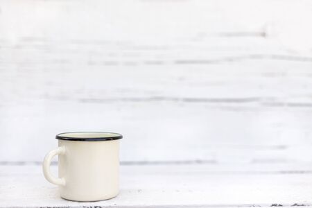 Enameled mugs in retro style on an old wooden background. Selective focus.の写真素材