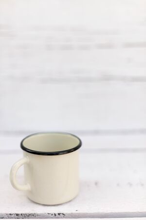 Enameled mugs in retro style on an old wooden background. Selective focus.の写真素材