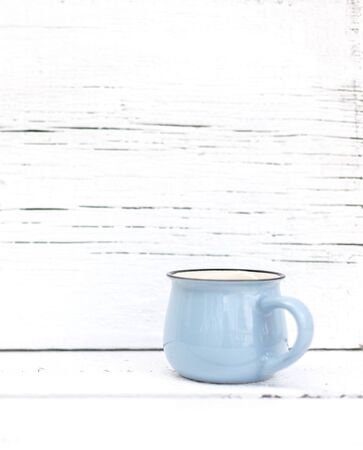 Enameled mugs in retro style on an old woodenの写真素材