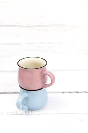 Enameled mugs in retro style on an old woodenの写真素材
