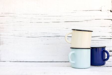 Enameled mugs in retro style on an old woodenの写真素材