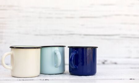 Enameled mugs in retro style on an old woodenの写真素材
