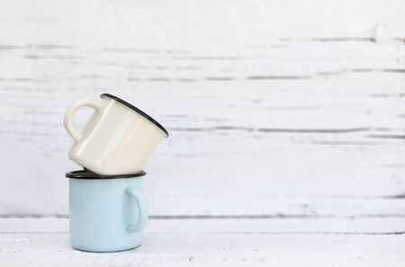 Enameled mugs in retro style on an old woodenの写真素材
