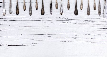 Vintage cutlery - spoons, forks and knives on an old woodenの写真素材