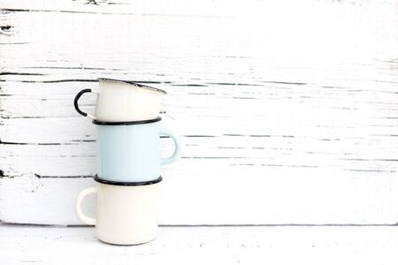 Enameled mugs in retro style on an old wooden background. Selective focus.の写真素材