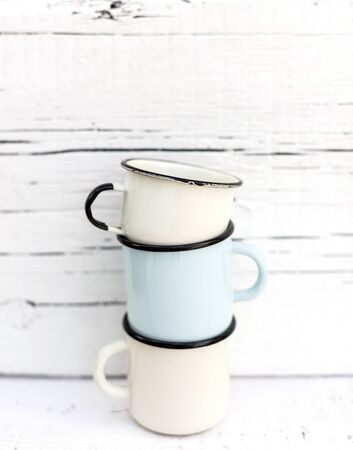 Enameled mugs in retro style on an old wooden background. Selective focus.の写真素材