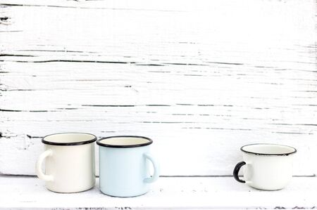 Enameled mugs in retro style on an old wooden background. Selective focus.の写真素材
