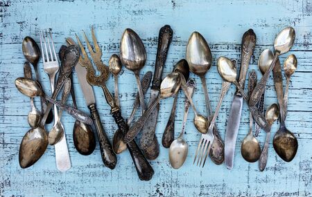 Vintage cutlery - spoons, forks and knives on an old woodenの写真素材