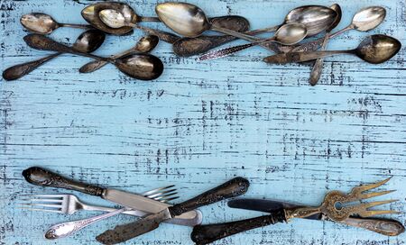 Vintage cutlery - spoons, forks and knives on an old woodenの写真素材