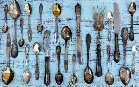 Vintage cutlery - spoons, forks and knives on an old woodenの写真素材