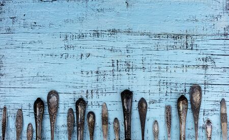 Vintage cutlery - spoons, forks and knives on an old woodenの写真素材