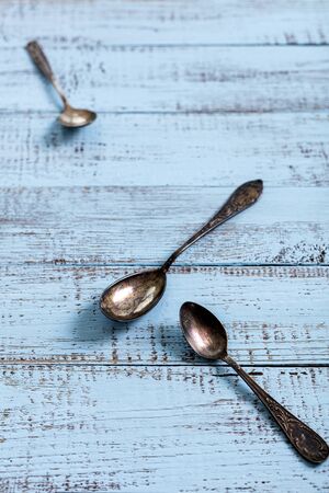 Vintage cutlery - spoons, forks and knives on an old wooden background. Selective focus.の写真素材
