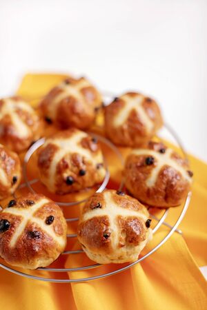 Buns marked with a cross and containing dried fruit, traditionally eaten during Lent. Selective...
