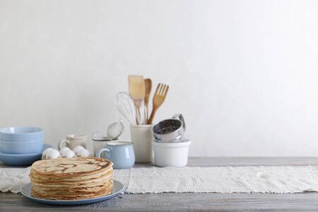 Cooking pancakes. Shrovetide (Maslenitsa) - blini stack on a blue plate on a wooden table. Selective focus.の写真素材