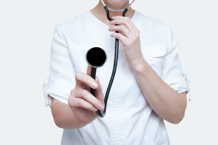 Woman doctor with a stethoscope in hands on a white background. Isolateの写真素材