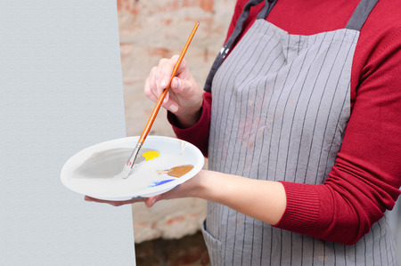Girl with a palette of colors in her hands. In the Art workshop.の写真素材