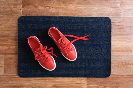 Red sneakers stand on a gray rug. View from above.の写真素材