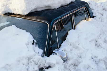 Dark blue car covered with snow drift. In the winter outside.の写真素材