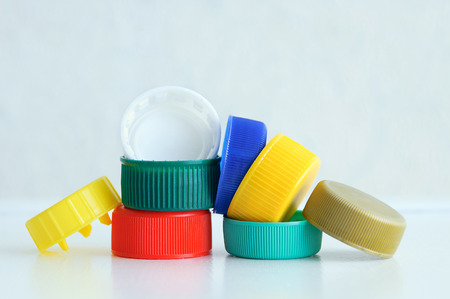 Ecology. Plastic multi-colored caps for bottles on a gray background. Close-up.の写真素材