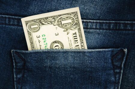 Dollar in the pocket of dark blue jeans close-up.