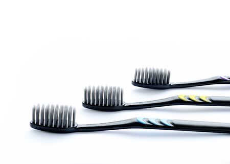 Three black toothbrushes with large carbon bristles. White background.の写真素材