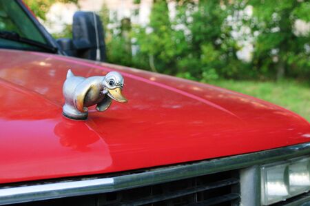 Russia 04-08 -2019. Metal duckling with a cigarette on the bumper of a red car close-up.