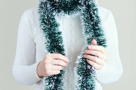 Caucasian girl in a white sweater with tinsel on the neck.の写真素材