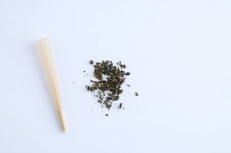 Cigarette paper with a filter and a handful of tobacco on a white background.の写真素材