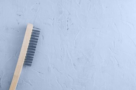 Brush with metal bristles to remove old paint. On a gray concrete background.の写真素材