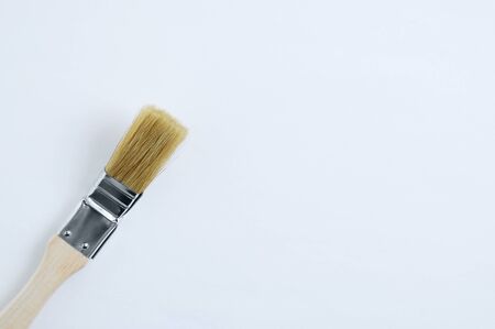 Brush for painting radiators with a wooden handle on white background. Place for textの写真素材