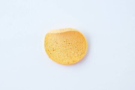 Dry wrinkled foam sponge for the face on a white background.