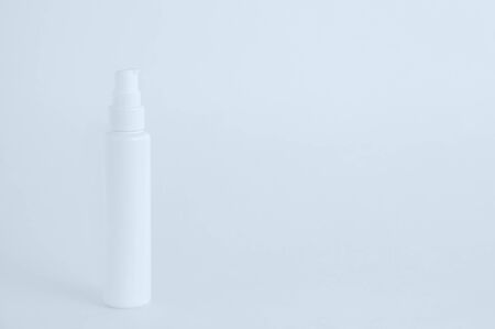 White plastic bottle with dispenser closeup on a white background. Face cream.の写真素材
