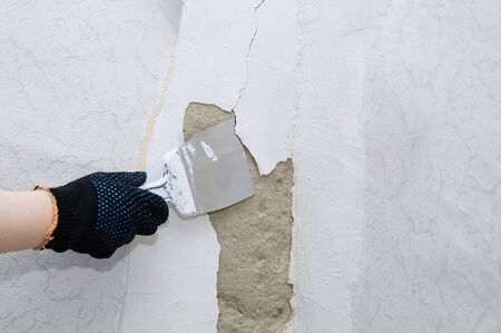Home improvement. Repair a damaged wall in a room. Plasterer at work.の写真素材