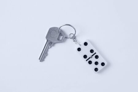 Key with a keychain in imitation of domino close-up on a white background.の写真素材