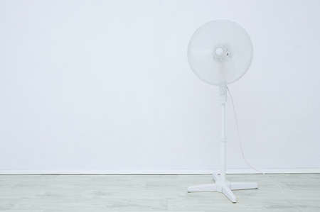 Floor fan in white in the interior of the room against the background of a white wall.の写真素材