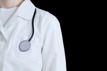 Caucasian female doctor in white coat with stethoscope. Black isolate.の写真素材